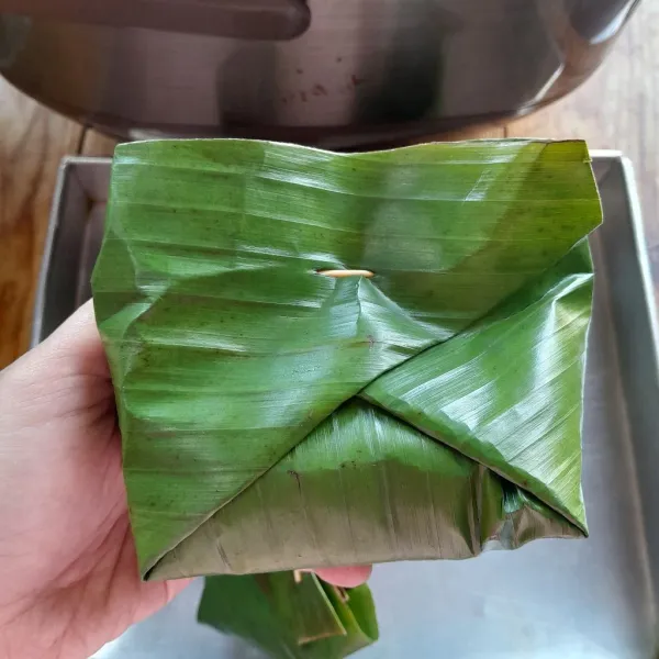 Membungkus : Ambil secukupnya daun pisang,masukkan secukupnya ampela bebek dan tahu yang sudah berbumbu. Tambahkan cabai rawit merah dan irisan tomat hijau di atasnya. Lipat daun sesuai selera. Lakukan hingga habis.