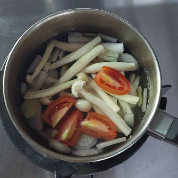 Tambahkan jamur dan tomat masak hingga jamur matang