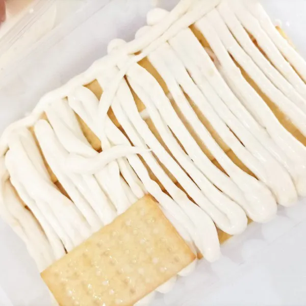 Lapisi atas biscuit dengan adonan whip cream, lalu lapisi lagi dengan biscuit ulangi hingga whip cream dan biscuit habis.