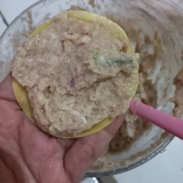 Siapkan kulit pangsit, ratakan adonan di permukaan, kemudian lipat ke bagian tengah. Dan tambahkan parutan wortel di atasnya.