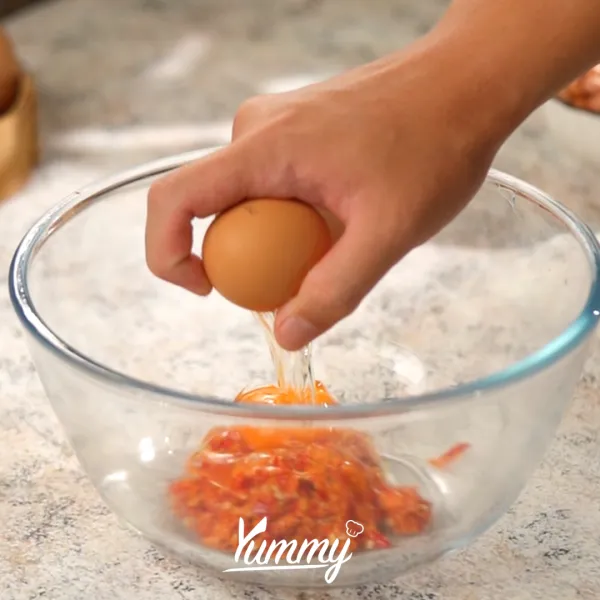Pecahkan telur kedalam wadah lalu tambahkan bumbu halus dan kaldu ayam bubuk, aduk hingga rata