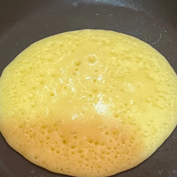 Tuangkan 1 sendok adonan pancake ke dalam teflon dan tunggu sampai berongga balik sebentar.