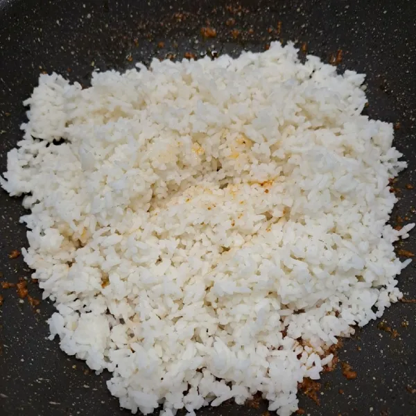 Masukkan nasi putih, aduk  sampai rata dengan bumbu.