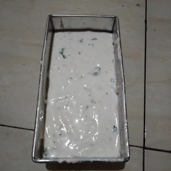 Olesi cetakan dengan minyak goreng alasi dengan plastik tahan panas lalu tuang adonan.