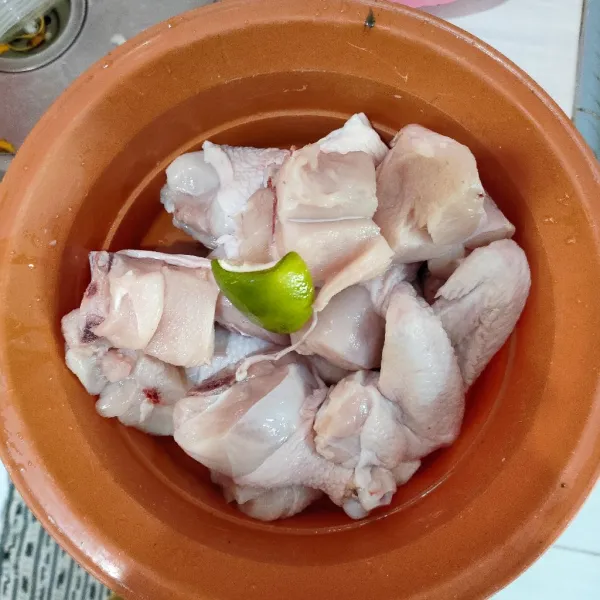 Bagi ayam menjadi 10 potong lalu lumuri ayam dengan perasan jeruk nipis, aduk merata