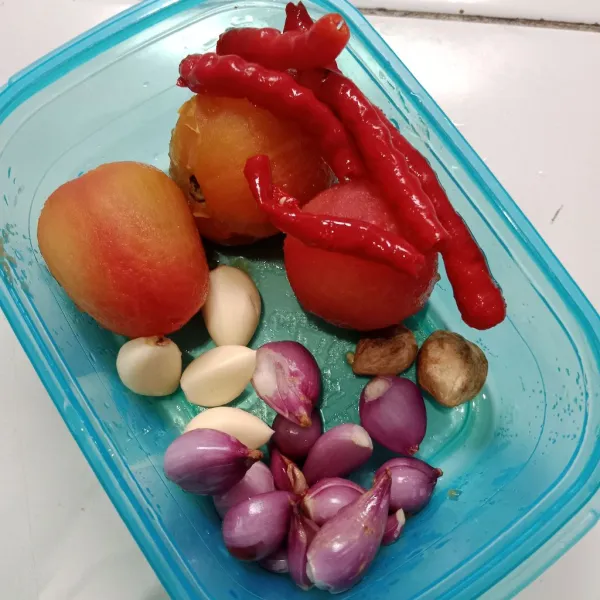 Siapkan bumbu halus. Kupas duo bawang, blanching cabai merah dan tomat agar warnanya merah cantik. Kupas kulit tomat, buang biji cabai. Haluskan bersama kemiri sangrai