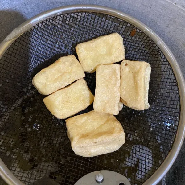 Potong masing-masing tahu menjadi 2 bagian lalu goreng