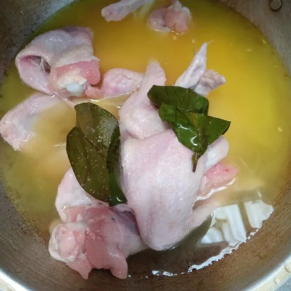 Masukkan bumbu halus, daun salam, ayam, dan air. Masak sampai air setengah surut.