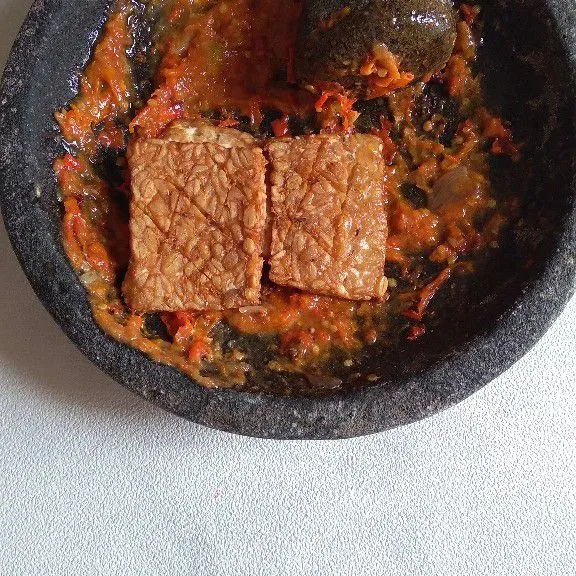 Masukkan tempe ke sambal kemudian penyet.