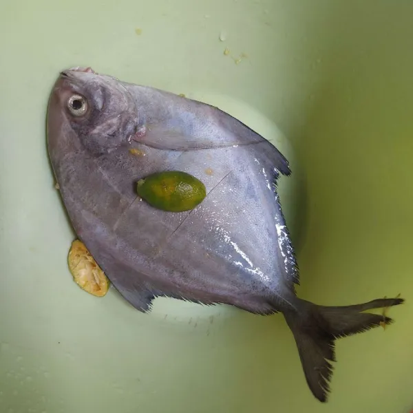 Bersihkan ikan bawal, lalu lumuri dengan air jeruk.