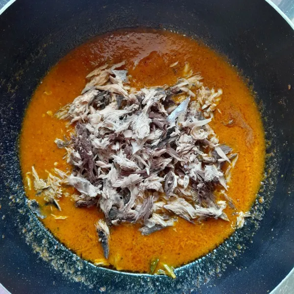 Kemudian tambahkan sedikit air dan masukkan suwiran ikan tongkol. Aduk rata, masak hingga bumbu meresap, menyusut dan berminyak. Koreksi rasa, setelah di rasa pas, matikan kompor.