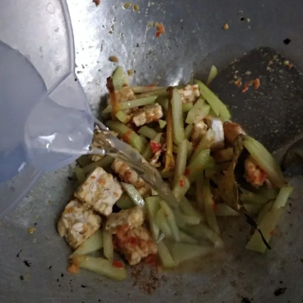 Masukkan air, tambahkan garam, gula dan penyedap. Masak sampai setengah matang.