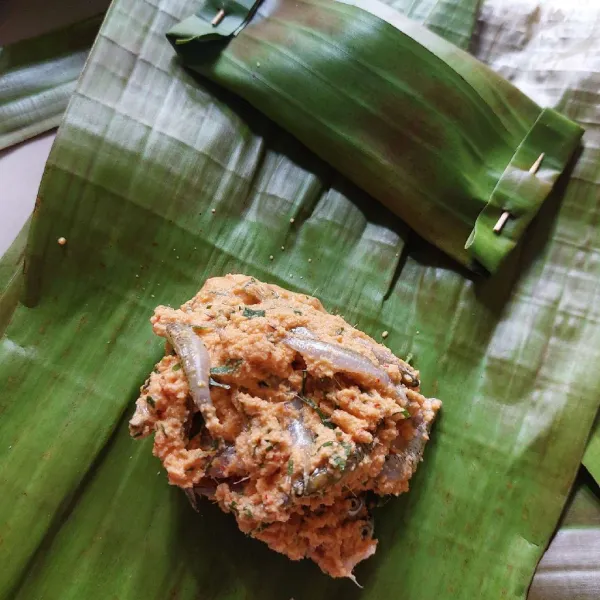 Bagi empat adonan dan bungkus masing-masing adonan dengan daun pisang, semat dengan rapat.