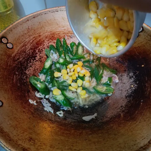 Masukkan jagung, beri sedikit air. Masak hingga jagung layu