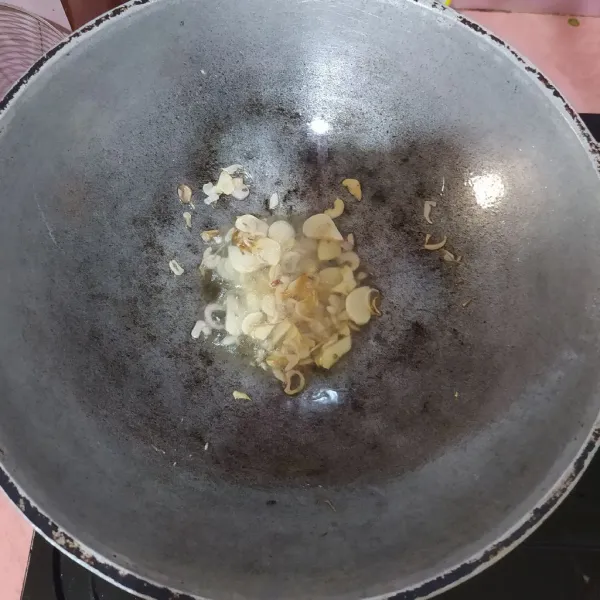 Tumis irisan bawang merah dan bawang putih sampai wangi.