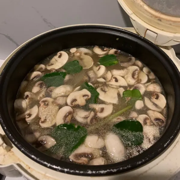 Pindah beras kedalam rice cooker. Beri daun jeruk. Tambahkan air kaldu ayam atau air biasa. Masak nasi seperti biasa dalam rice cooker.