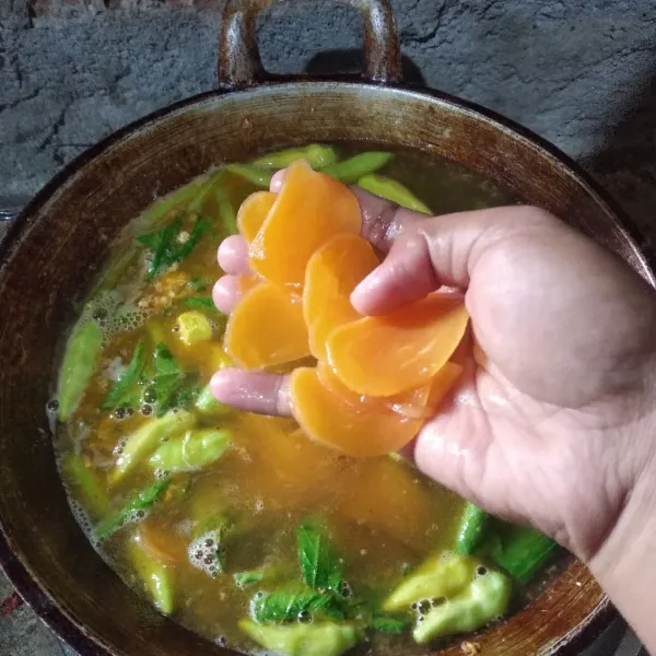 Tambahkan kerupuk yang sudah layu alias empuk dan tahu kuning. Masak hingga air mendidih kembali.