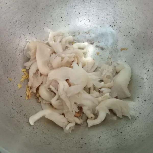 Masukkan jamur tiram, aduk rata lalu tuang air.