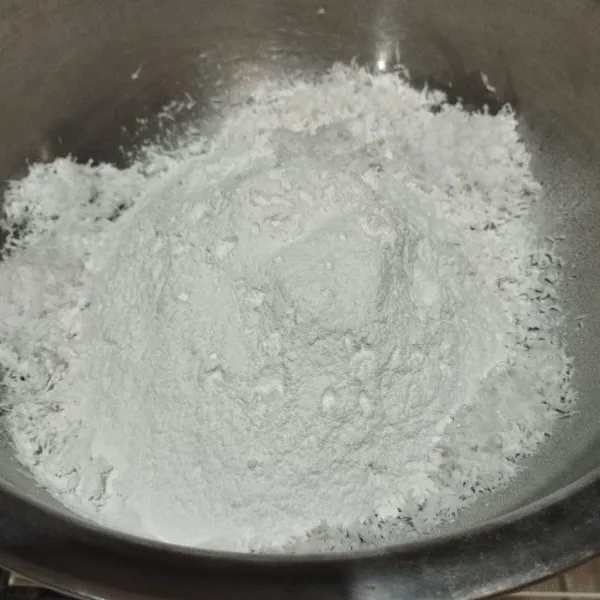 Dalam wadah yg agak besar.masukkan kelapa parut,tepung ketan sambil di ayak.tambahkan garam dan vanili.aduk merata