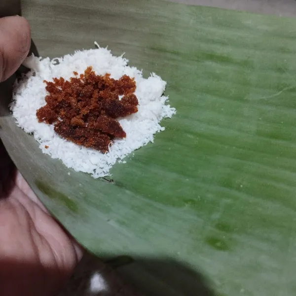 Ambil daun pisang,masukkan 1 sendok adonan.lalu tambahkan gula merah secukupnya.lalu bungkus dan semat dg lidi.lakukan sampai selesai.