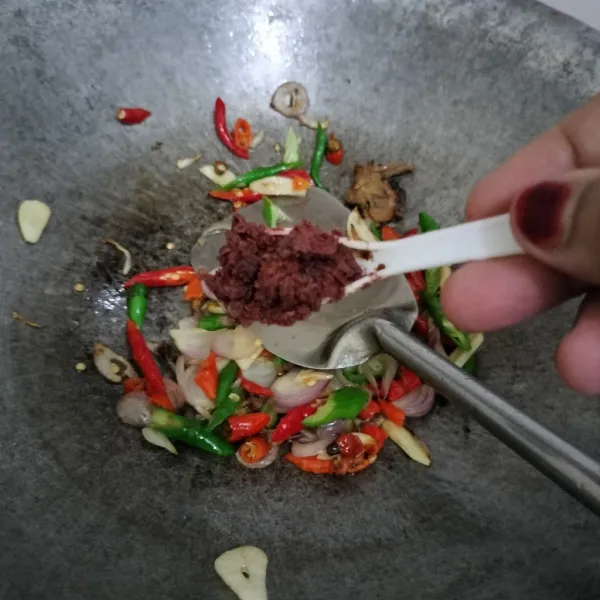 Tambahkan terasi, tumis hingga tercampur rata.