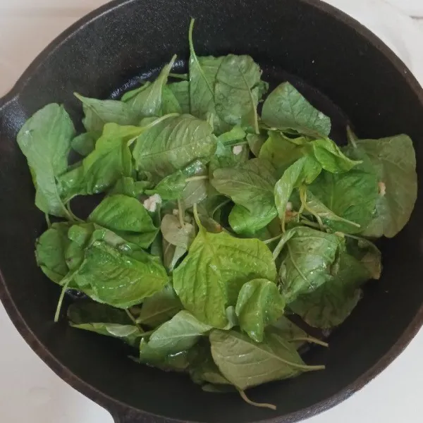 Tumis bawang putih dan bayam. Beri garam, lada, bumbu penyedap secukupnya. Tumis hingga matang.