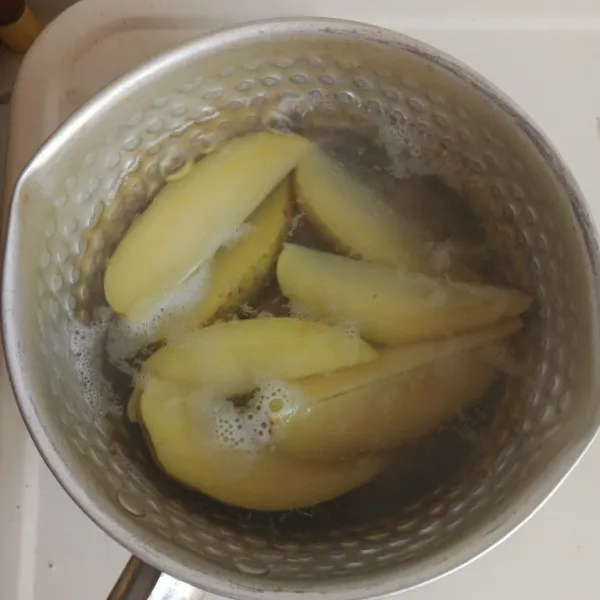 Potong kentang berbentuk wedges dan rebus sampai matang.