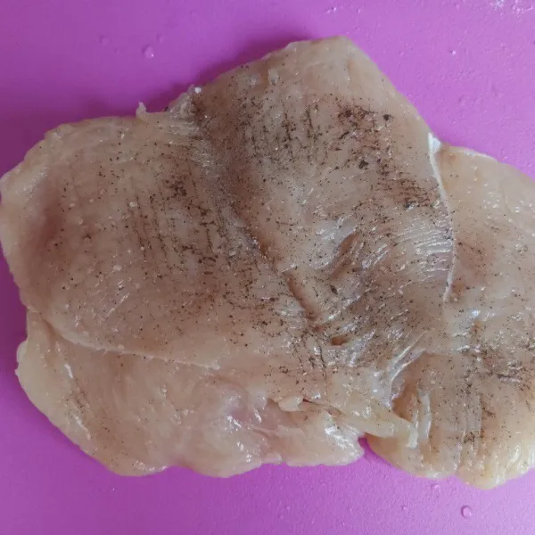 Tipiskan dada ayam dengan cara membelahnya menjadi 2 tapi tidak putus. Pukul-pukul dengan pisau. Marinasi dengan garam, lada hitam, dan bubuk bawang putih selama 10 menit.