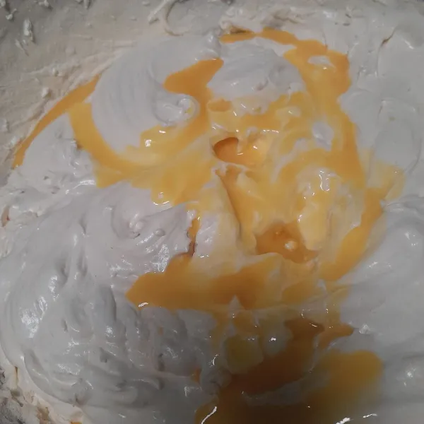 Masukan lelehan margarin yang di beri essence pisang, aduk balik dengan spatula.