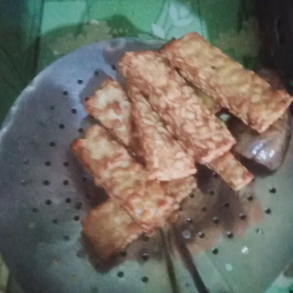 Goreng tempe dengan minyak banyak panas hingga matang kecoklatan angkat tiriskan.