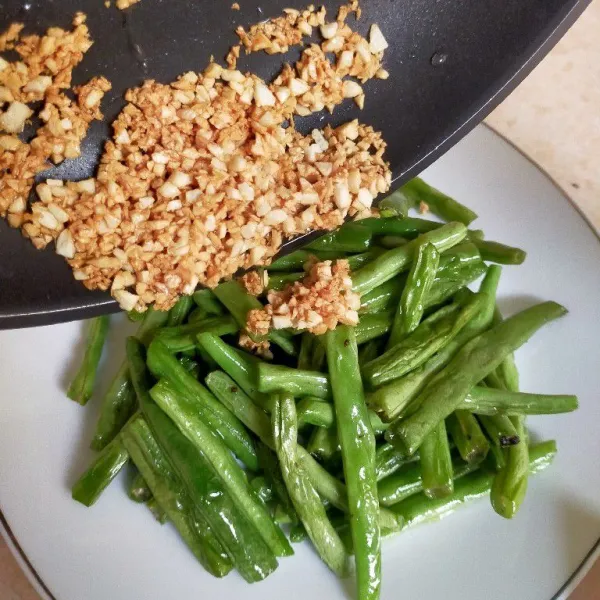 Siram bawang diatas buncis yang sudah digoreng.