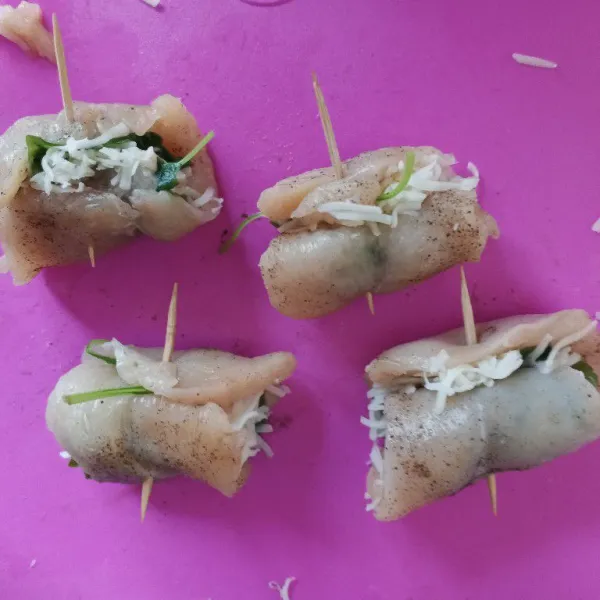 Gulung ayam dan tahan bentuknya dengan tusuk gigi.