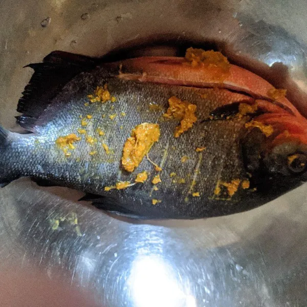 Marinasi ikan dengan bumbu instan ikan goreng yang sudah diberi sedikit air.