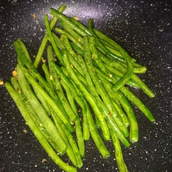 Masukkan buncis, lalu beri air, aduk rata, masak hingga panas.