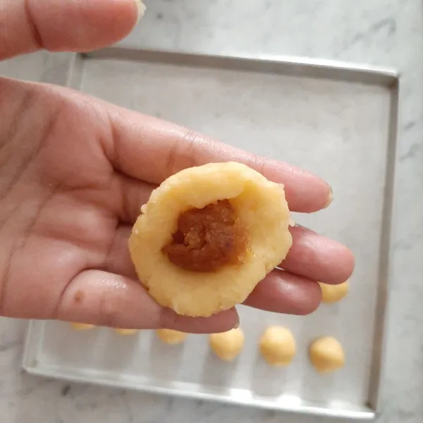 Timbang dan bulat-bulatkan adonan, besar nya bisa di sesuaikan dengan selera, saya buat ukurannya agak besar besar, pipihkan adonan lalu isi dengan selai nanas dan bentuk bola.