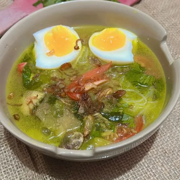 Susun bihun, irisan daun seledri, irisan tomat bawang goreng dan telur yang sudah di rebus, kemudian siram dengan kuah soto yang tadi, langkah terakhir taruh jeruk untuk cita rasa lebih segar, soto simpel siap dinikmati.