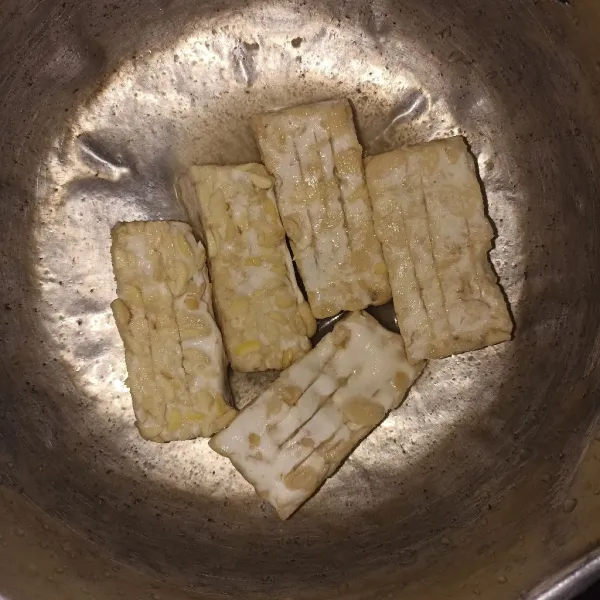 Marinasi tempe dengan bumbu bawang, garam, merica, dan sedikit air