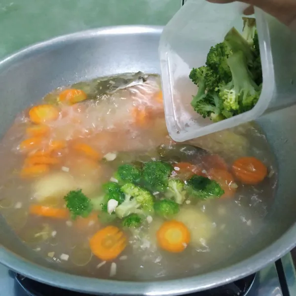 Tambahkan brokoli, daun bawang, daun seledri dan bakso sapi. Masak hingga bakso mekar.