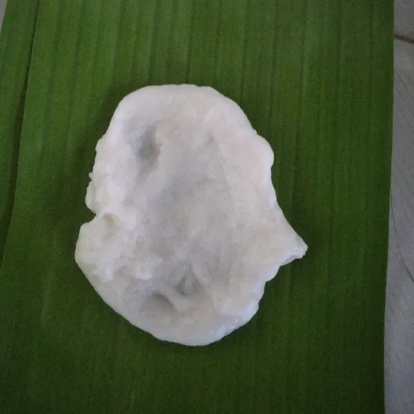 Potong potong daun pisang. Ambil 1 sdm adonan, pipihkan di atas daun pisang.