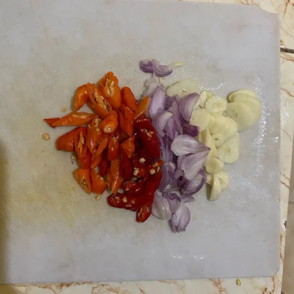 Iris tipis cabai rawit merah, bawang putih, bawang merah.