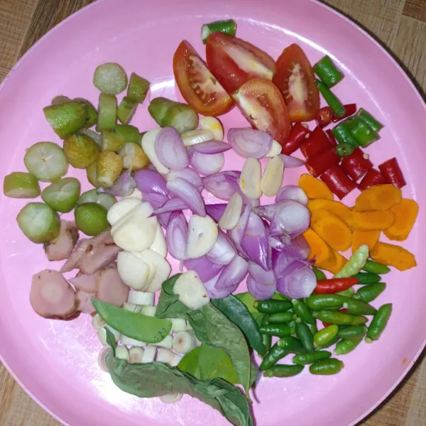 Potong-potong cabai besar, tomat, belimbing, bawang putih, bawang merah, lengkuas, jahe, serai
