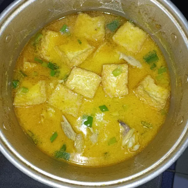 Masukkan tahu yang sudah dipotong dan digoreng, tambahkan garam dan penyedap, setelah sayur mendidih, tambahkan potongan daun bawang dan sajikan.