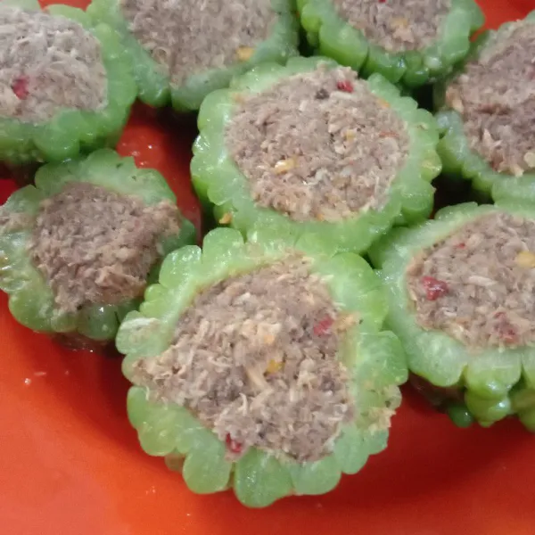 Cuci bersih pare yang sudah diberi garam tadi. Cuci berkali-kali hingga air cuciannya tidak berbusa sama sekali. Isikan kambu pada bagian tengah pare, tekan hingga padat, kemudian sisihkan.