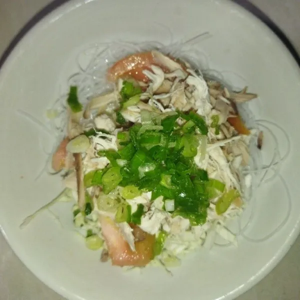 Siapkan mangkuk saji, tata kol, soun, potongan tomat daun bawang dan ayam suwir, siram kuah soto lalu taburi bawang goreng dan bawang putih goreng, sajikan dengan sambal dan perasan air jeruk limau.