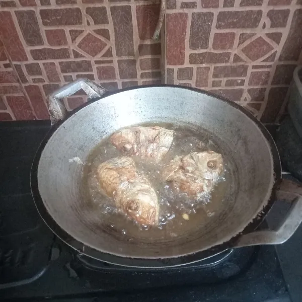 Goreng ikan sampai berubah warna dan matang.