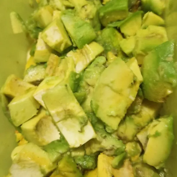 Kupas buah alpukat, potong dadu sesuai selera