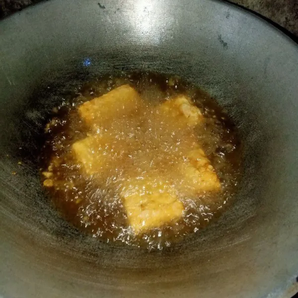 Setelah minyak panas, masukkan tempe dan goreng menggunakan api sedang. Bila bagian bawah sudah mulai kecoklatan, baru dibalik.