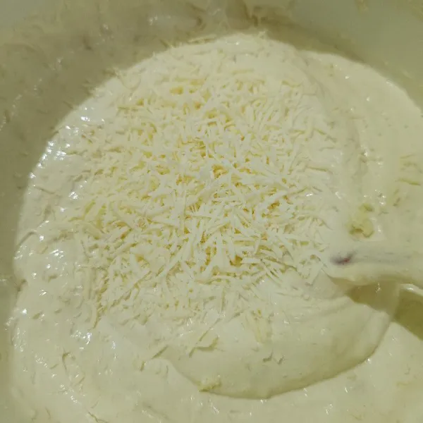 Masukkan margarin cair, aduk kembali dan keju parut aduk hingga rata