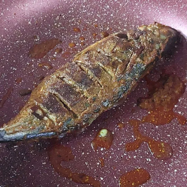 Panaskan teflon dengan api kecil, lalu bakar kedua sisi ikan sampai matang. Teflon tidak perlu lagi diberi minyak karena bumbu sudah berminyak.