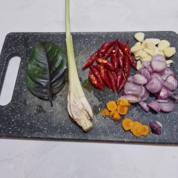 Iris bawang putih, bawang merah, kunyit, dan cabe keriting. Tumbuk serai dan daun salam.